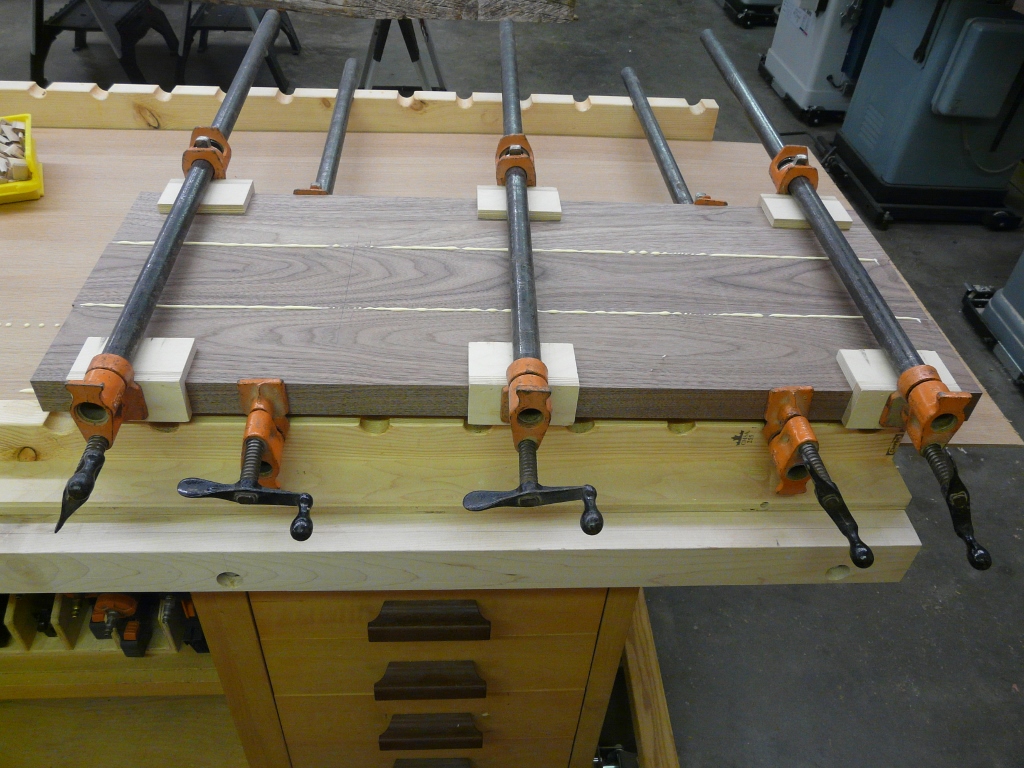 A good flat surface is needed for the clamping.  Make sure to clamp both top and bottom for even clamp pressure.  I dont worry about trying to remove the squeeze out until it has been clamped for 2 hours.  At that time you can use a glue scraper and it will easily come off. Dont wait to long though or it will dry to much and tear the grain of the joint when scraping.