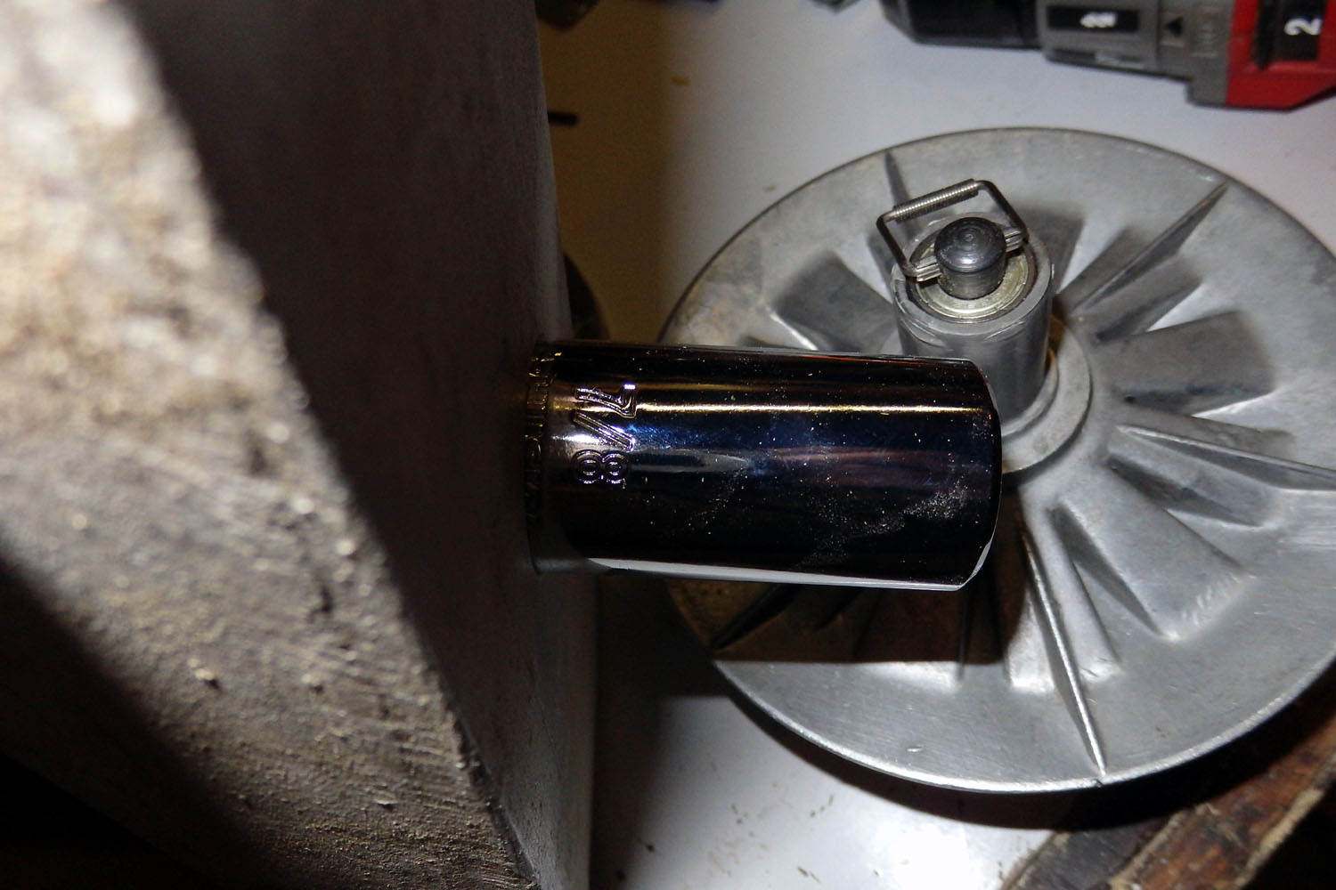7/8" deep well 6 point socket, set 1/2" into 2x4. Deep well allows retaining loop and roll pin to remain installed thru hole in button while squeezing it all together