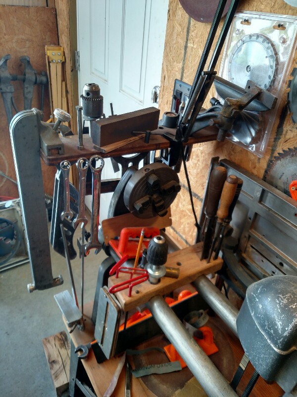 The left end with my tool holder, the tailstock off my 10E (dedicated drill press), the 10E auxillary table, the storage for the chuck, toolrest, drill chucks, fence, etc.