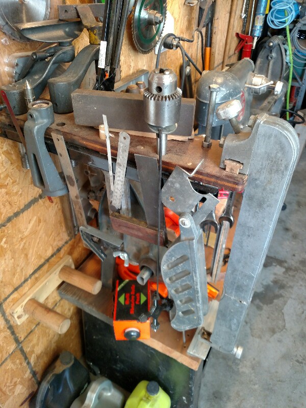 Next picture shows the other side with a magnetic strip to hold the blade guard, try square,combination square, a couple 6" rules, and so on. Note the extreme lower left corner there are two 1¾ dowels mounted to the wall where I can store the 10E tailstock when I take it off. That tailstock and aux table can also be cleared and used as a work support to the left of the saw.