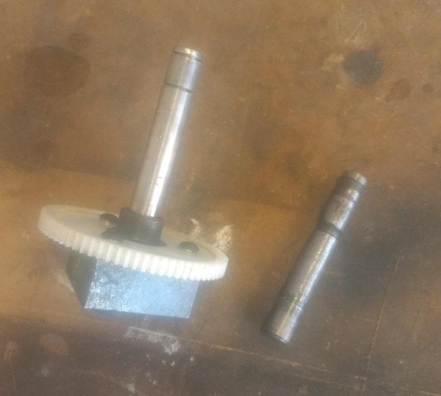The new shaft on the weight assembly and the old shaft alongside it.